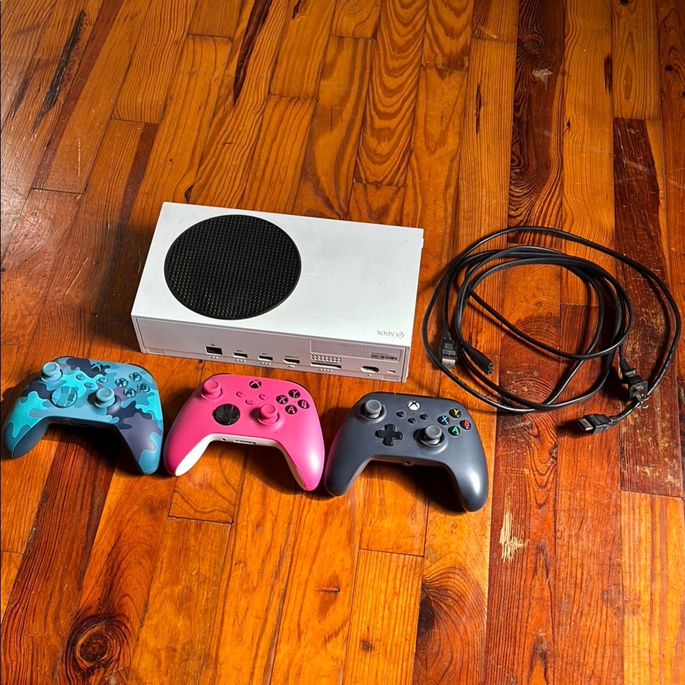 Xbox Series S with Blue, Pink, and Black Controllers